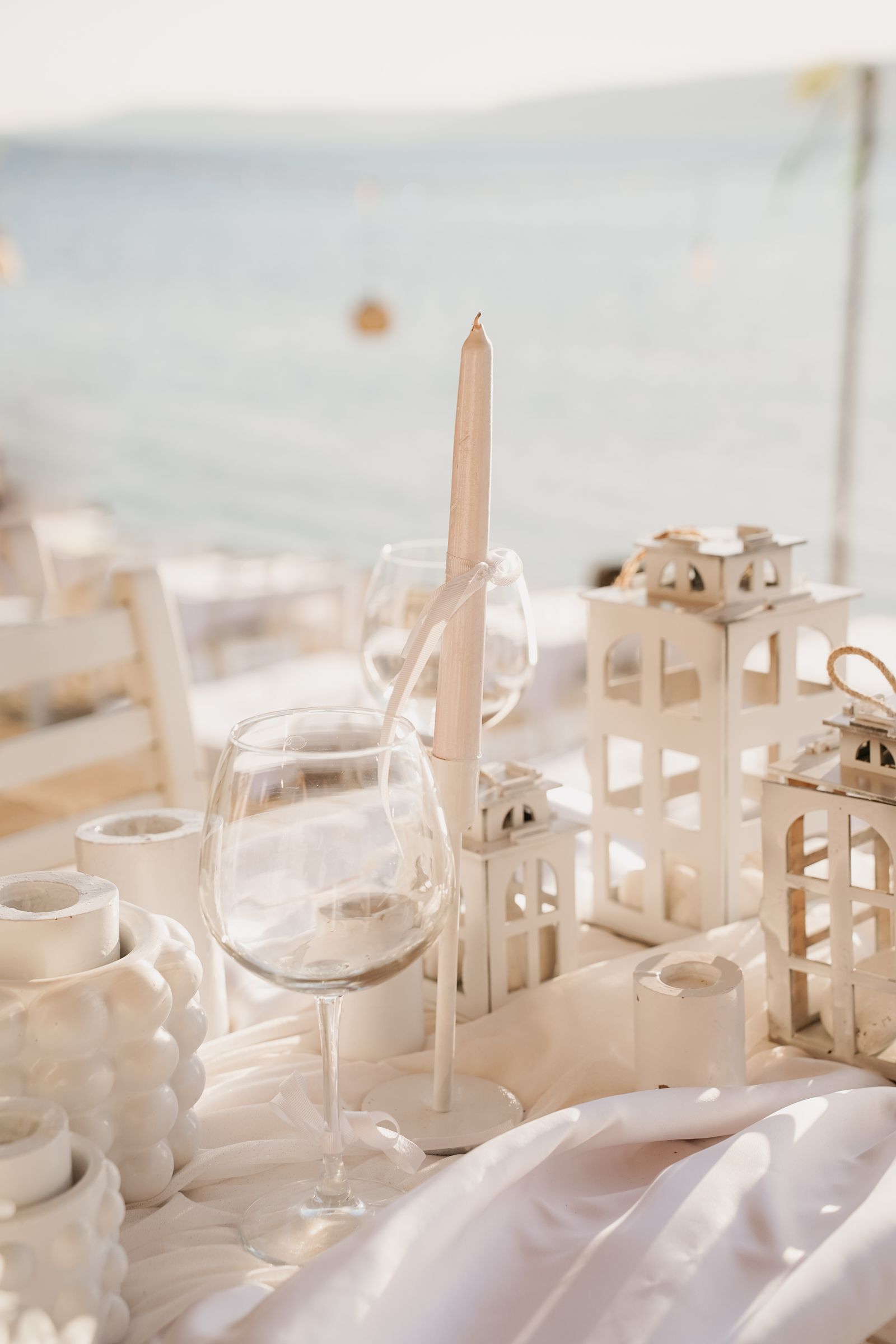 Styling inspiration: ivory table linen, glassware and candles beside the coast; not photographed at Ocean’s